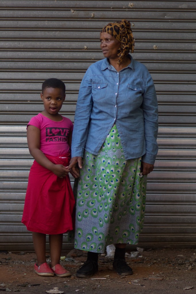 Beeld Nuus - 290915JPH - Elizabeth Msomi and her granddaughter Athandwa (6yrs old) outside the building in Jeppestown that was allegedly petrol bombed on 29 September 2015. Both only have the clothes they are wearing as most of their belongings were burnt. Foto: Jabulile Pearl Hlanze
