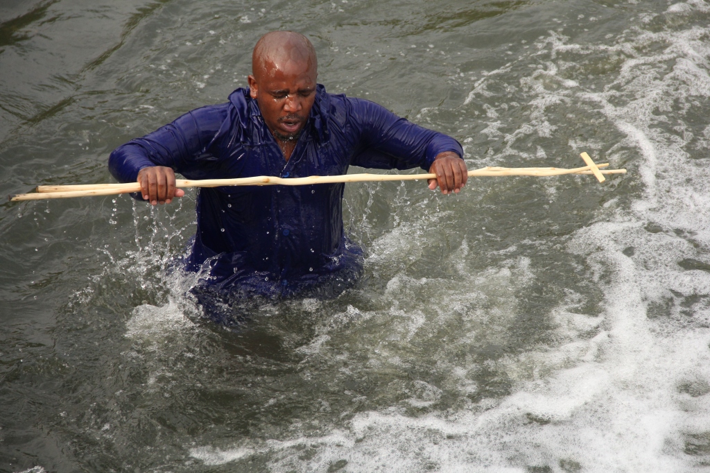 SOUTH AFRICA: A man from Zion Church jumps out of the water, holding his staff on 04 April 2015, in Vlakplaats Street, Vosloorus Ext 32 for the Easter Weekend celebrations. © JABULILE PEARL HLANZE